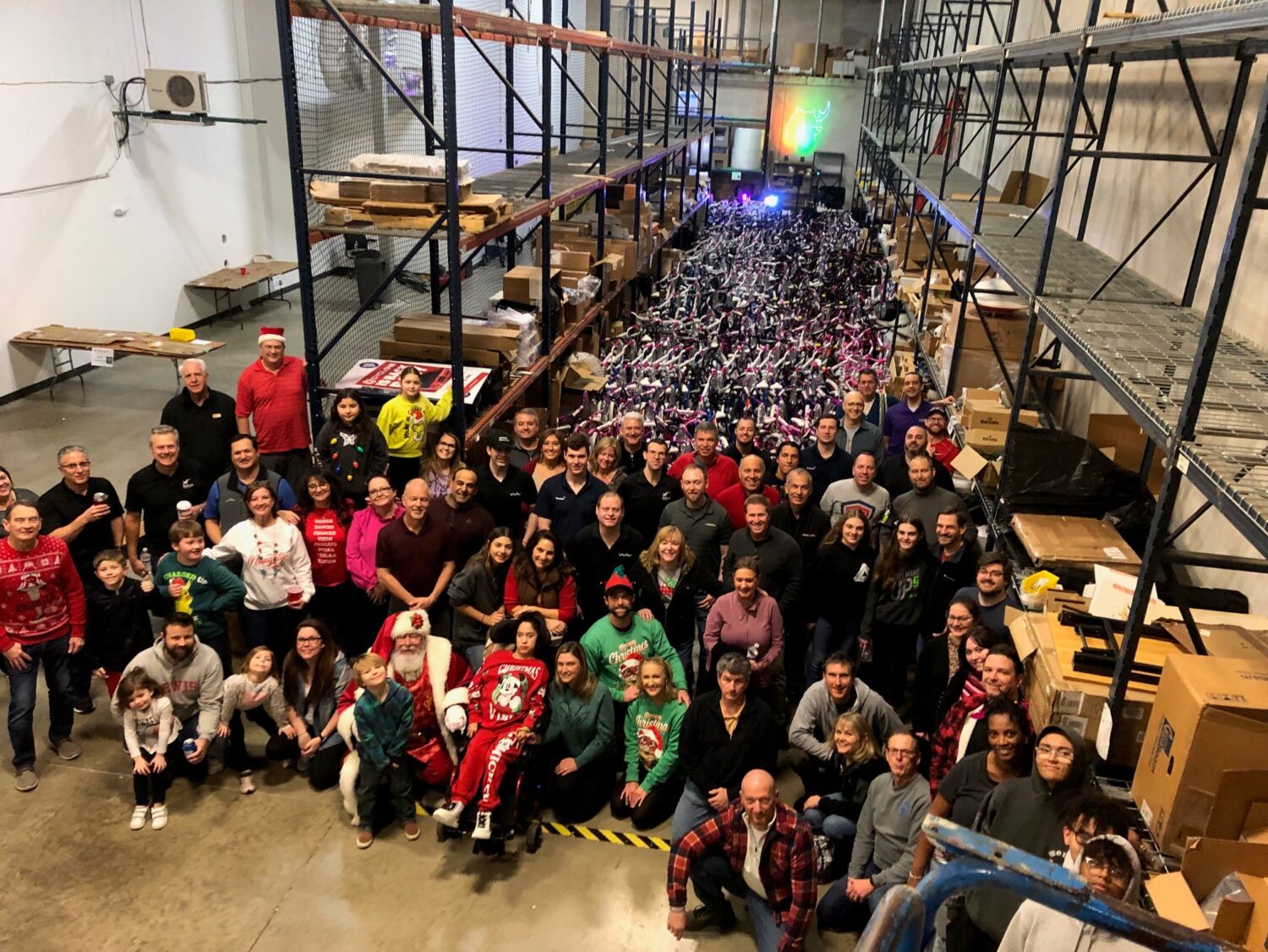 A group of people standing in front of a warehouse full of bikes